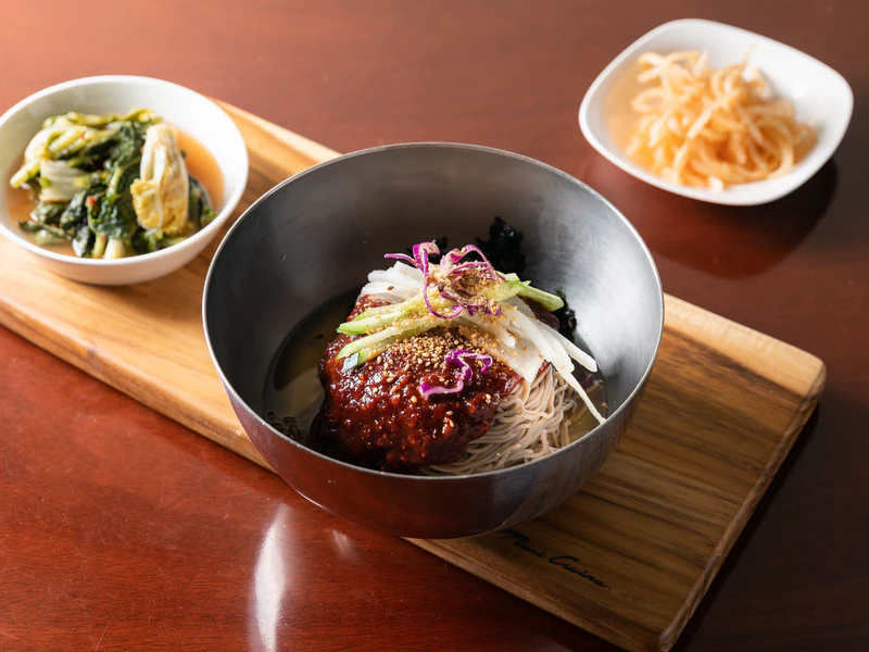 메밀면 위에 붉은 양념을 올린 비빔막국수